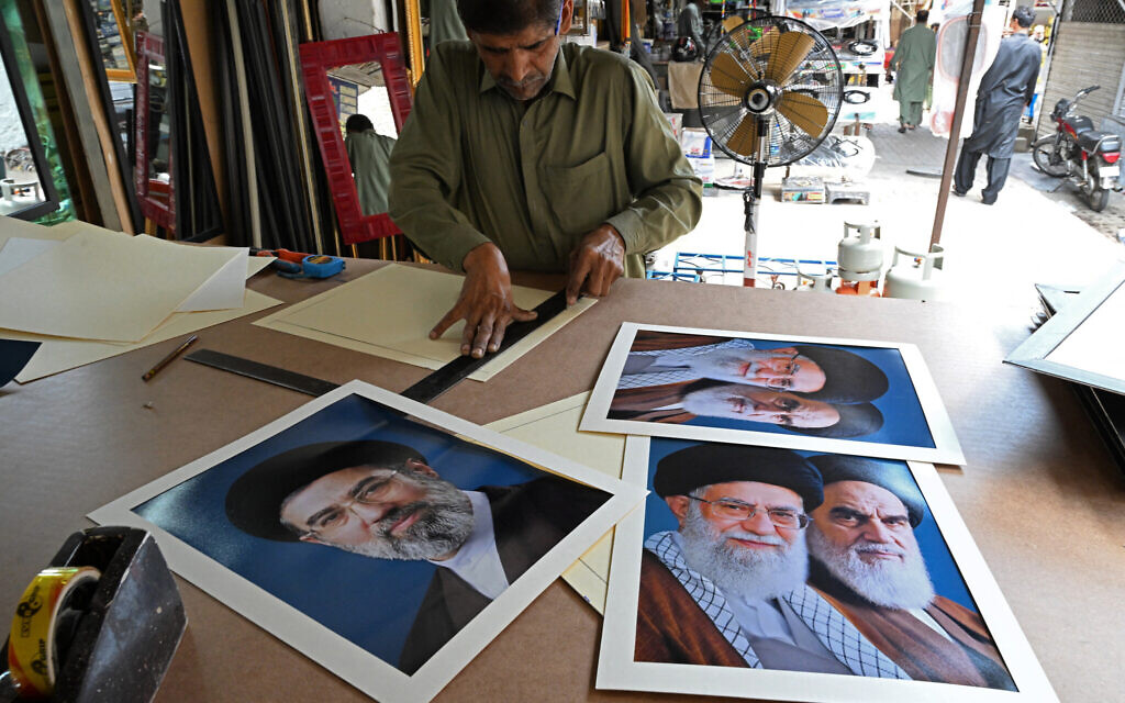 An artisan prepares portraits of Iran's newly elected supreme leader Mojtaba Khamenei (L), alongside former leaders Ruhollah Khomeini (R) and Ali Khamenei (C) at a market in Islamabad on April 29, 2026. (Aamir QURESHI / AFP)