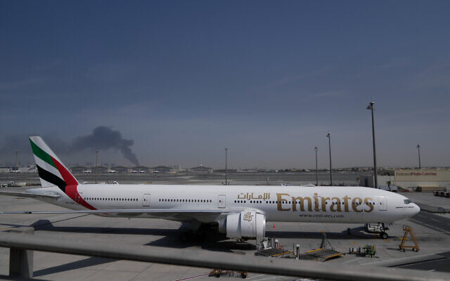 A plume of smoke caused by an Iranian strike is seen in the background an an Emirates plane is parked at the Dubai International Airport after its closure in Dubai, United Arab Emirates, March 1, 2026. (AP Photo/Altaf Qadri) A plume of smoke caused by an Iranian strike is seen in the background an an Emirates plane is parked at the Dubai International Airport after its closure in Dubai, United Arab Emirates, March 1, 2026. (AP Photo/Altaf Qadri)