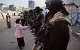 Armed members of Hamas and Islamic Jihad greet people gathering for Eid al-Fitr prayers in Gaza City, Friday, March 20, 2026. (AP/Abdel Kareem Hana)
