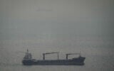 A cargo ship carrying vehicles sails through the Arabian Gulf toward the Strait of Hormuz in the United Arab Emirates, March 22, 2026. (AP Photo)
