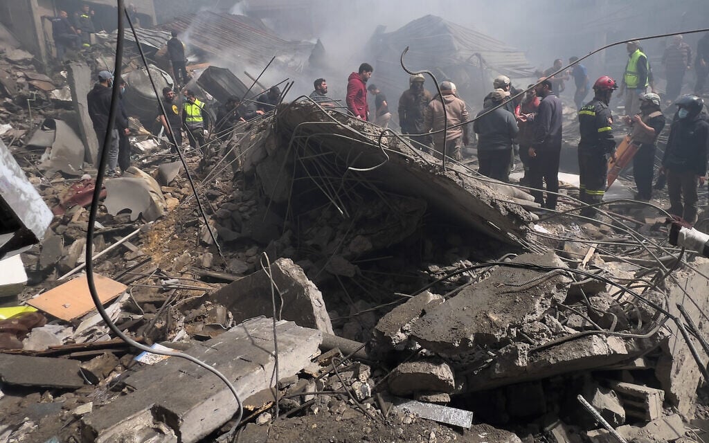 Rescue workers search for victims at the site of an Israeli airstrike that hit a crowded neighborhood south of Beirut, Lebanon, April 5, 2026. (AP Photo/Hussein Malla)