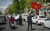 A government supporter waves a flag honoring the martyrdom of Imam Hussein, a revered figure in Shiite Islam, across from the Foreign Ministry in Tehran, Iran, April 5, 2026. (AP