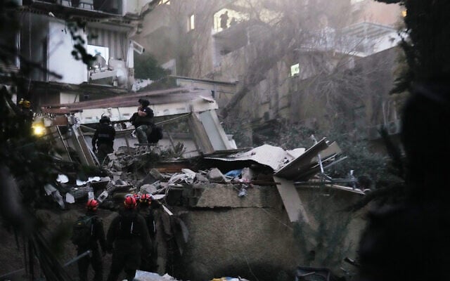 Israeli security forces and rescue teams work amid the rubble of a residential building struck by an Iranian missile in Haifa, Israel, April 5, 2026. (AP Photo/Ariel Schalit)