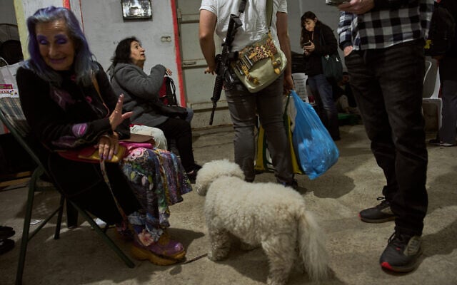 People take cover in a bomb shelter as air raid sirens warn of an Iranian ballistic missile attack in Ramat Gan, April 7, 2026. (AP Photo/Oded Balilty)