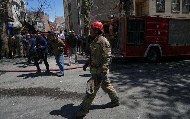 A first responder walks near the site of a strike that, according to an Iranian security official at the scene, destroyed half of a synagogue and nearby residential buildings in Tehran, Iran, April 7, 2026. Iranian state media said a synagogue was badly damaged in what it claimed was an Israeli strike. Israel's Foreign Ministry said it was looking into the incident. (AP Photo/Francisco Seco)