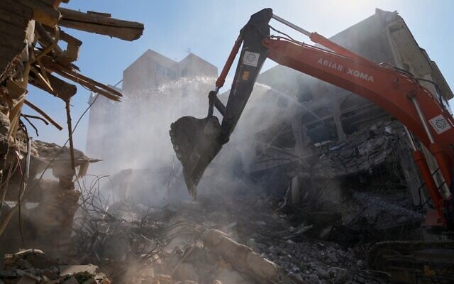 An excavator removes rubble at the site of a strike that, according to Iranian media reports, destroyed half of the Khorasaniha Synagogue and nearby residential buildings in Tehran, Iran, April 7, 2026. (AP Photo/Francisco Seco)