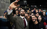 Hasan Piker, left, and Abdul El-Sayed, a progressive candidate in the Democratic primary for US Senate in Michigan, center right, take a selfie with young fans following a campaign event, April 7, 2026, at the University of Michigan in Ann Arbor, Michigan. (AP Photo/Julia Demaree Nikhinson)
