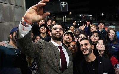 Hasan Piker, left, and Abdul El-Sayed, a progressive candidate in the Democratic primary for US Senate in Michigan, center right, take a selfie with young fans following a campaign event, April 7, 2026, at the University of Michigan in Ann Arbor, Michigan. (AP Photo/Julia Demaree Nikhinson)
