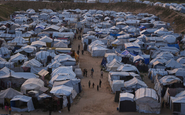 Palestinians walk along tents at a makeshift camp for displaced people in Khan Younis, southern Gaza Strip, April 9, 2026. (AP/Abdel Kareem Hana) Palestinians walk along tents at a makeshift camp for displaced people in Khan Younis, southern Gaza Strip, April 9, 2026. (AP/Abdel Kareem Hana)
