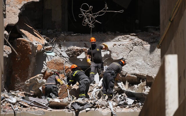 Lebanese rescuers search through rubble for the body of a missing student, at the site of a building destroyed in an Israeli airstrike days earlier, in central Beirut, Lebanon, April 11, 2026. (AP Photo/Hassan Ammar)