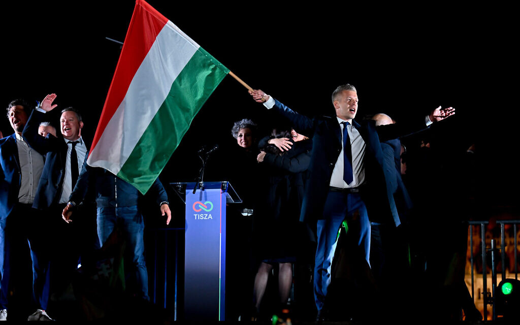 Peter Magyar, leader of the opposition Tisza party, waves the Hungarian flag following the announcement of the partial results of the parliamentary election, in Budapest, Hungary, Sunday, April 12, 2026. (AP Photo/Denes Erdos)