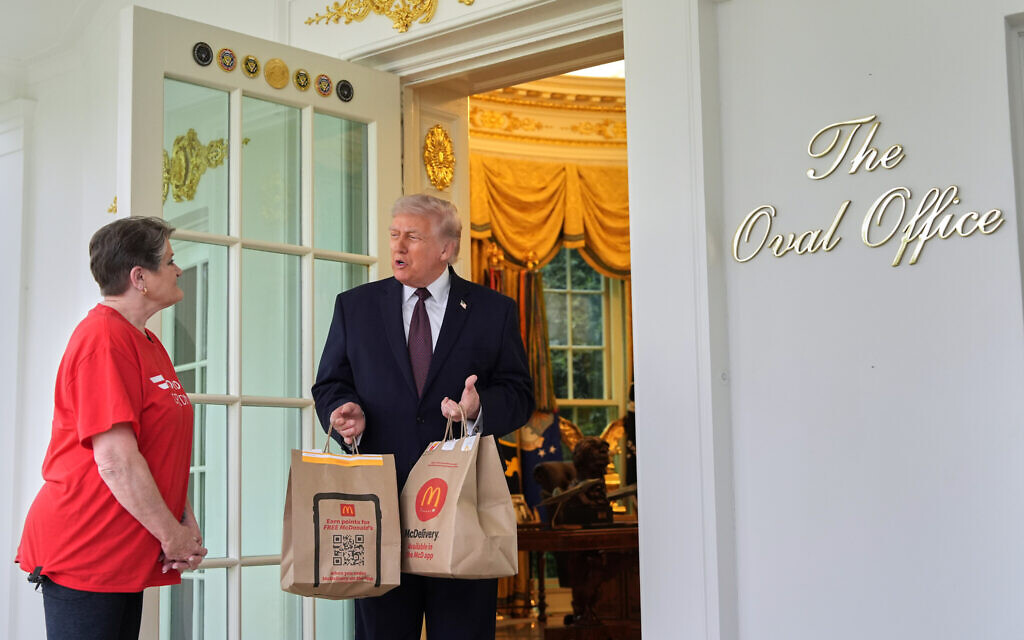 US President Donald Trump speaks to Sharon Simmons, a DoorDash driver from Arkansas, who delivered him two bags of McDonald's food outside the Oval Office of the White House, April 13, 2026, in Washington. (AP Photo/ Alex Brandon)