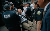 Protesters with Jewish Voice for Peace get arrested after blocking traffic during a demonstration outside the New York office of U.S. Sen. Chuck Schumer, calling for an end to the US-Israel war with Iran and opposing US weapons support on Monday, April 13, 2026, in New York. (AP Photo/Andres Kudacki)