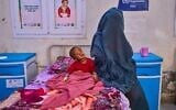 Hashem Abderaman sits in his bed next to his mother while receiving treatment at the paediatric hospital stabilization center in Port Sudan, Sudan, April 15, 2026. (AP Photo/Bernat Armangue)