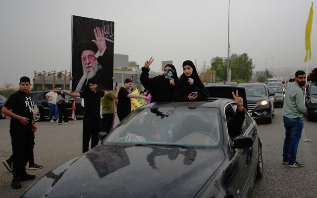 Displaced residents hold portraits of late Iran's Supreme Leader Ayatollah Ali Khamenei, left, and late Hezbollah leader Hassan Nasrallah as they drive back to their villages, in Jiyeh, near Saida, southern Lebanon, Friday, April 17, 2026, following a ceasefire between Israel and Hezbollah. (AP Photo/Hassan Ammar)