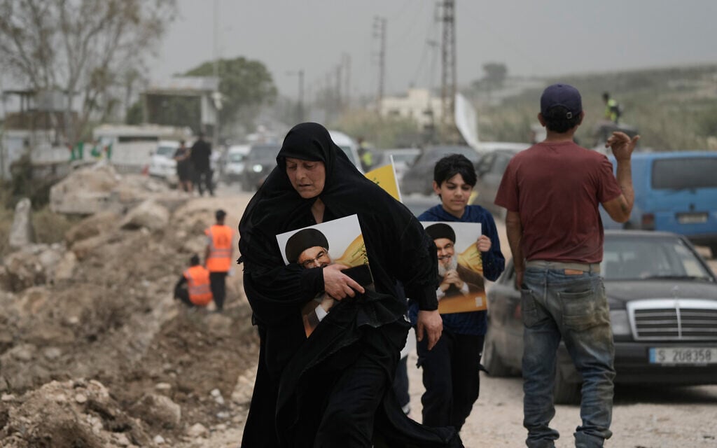 Displaced people hold portraits of late Hezbollah leader Hassan Nasrallah, as they cross on foot while returning to their villages on the second day of a ceasefire between Hezbollah and Israel in Qasmiyeh, near Tyre city, southern Lebanon, April 18, 2026. (AP Photo/Bilal Hussein) Displaced people hold portraits of late Hezbollah leader Hassan Nasrallah, as they cross on foot while returning to their villages on the second day of a ceasefire between Hezbollah and Israel in Qasmiyeh, near Tyre city, southern Lebanon, April 18, 2026. (AP Photo/Bilal Hussein)