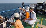 In this picture courtesy of Captain Rahman Al-Jubouri, he, right, supervises sailors on the deck of the Sea Moon oil tanker on the waters the Gulf of Oman, April 15, 2026. (Photo courtesy of Capt. Rahman Al-Jubouri via AP)