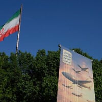 A banner shows a graphic depicting Iranian-built drones with a sign in Farsi that reads: "Arash drone is the nightmare for Iran's enemies," as an Iranian flag waves at left, in Tehran, Iran, April 21, 2026. (AP Photo/Vahid Salemi)