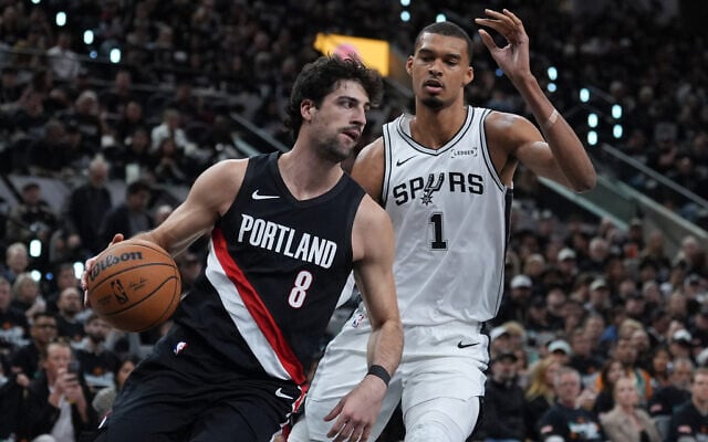 Portland Trail Blazers forward Deni Avdija (8) drives around San Antonio Spurs forward Victor Wembanyama (1) during the first half in Game 2 of a first-round NBA playoffs basketball series in San Antonio, April 21, 2026. (AP Photo/Eric Gay)