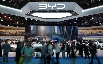 Visitors tour Chinese automaker BYD's booth with a screen showing its battery charging station under sub-zero temperatures, at the Auto China 2026 show in Beijing, April 25, 2026. (AP/Andy Wong)