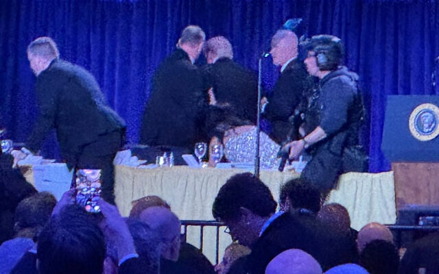 US Secret Service agents surround President Donald Trump, third from left, as he is taken from the stage after a shooting incident outside the ballroom during the White House Correspondents Dinner, April 25, 2026, in Washington. (AP Photo/Mark Schiefelbein) US Secret Service agents surround President Donald Trump, third from left, as he is taken from the stage after a shooting incident outside the ballroom during the White House Correspondents Dinner, April 25, 2026, in Washington. (AP Photo/Mark Schiefelbein)