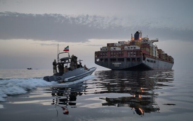 FILE - In this photo released by Tasnim News Agency, a Revolutionary Guard Navy (IRGC) speedboat approaches the cargo ship Epaminondas during what state media described as the seizure of one of two vessels accused of violations in the Strait of Hormuz, April 21, 2026. (Meysam Mirzadeh/Tasnim News Agency via AP, File)