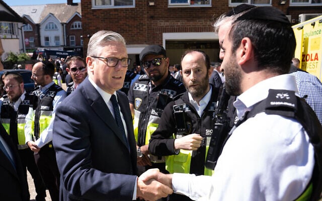 Britain's Prime Minister Keir Starmer, left, meets first responders from Shomrim North West London during a visit to Golders Green, April 30, 2026. (Stefan Rousseau/Pool via AP)