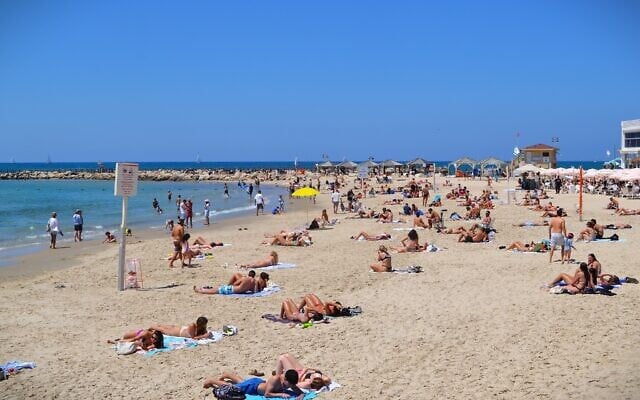 People at the beach in Tel Aviv on Independence Day, April 22, 2026. (Stav Levaton/Times of Israel)