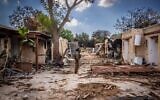 Israeli soldiers look around the destruction caused by Hamas terrorists in Kibbutz Kfar Aza, near the Israeli-Gaza border, in southern Israel, October 15, 2023. (Oren Ben Hakoon/Flash90)
