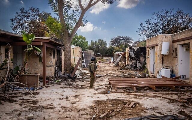 Israeli soldiers look around the destruction caused by Hamas terrorists in Kibbutz Kfar Aza, near the Israeli-Gaza border, in southern Israel, October 15, 2023. (Oren Ben Hakoon/Flash90)