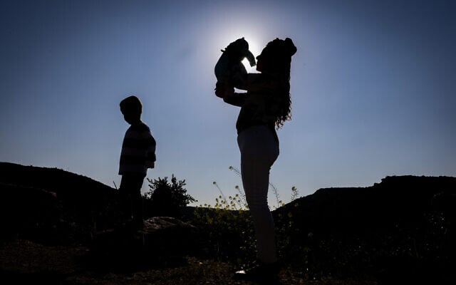 In a photo taken on February 21, 2024, Revital Shamir with her 4-year-old son Lavi and newborn girl Ori are at their home in Havat Yair (Yair's Farm). Revital's husband Mordechai was killed in military service while fighting Hamas terrorists at Kibbutz Re'im on October 7, 2023. (Chaim Goldberg/FLASH90)