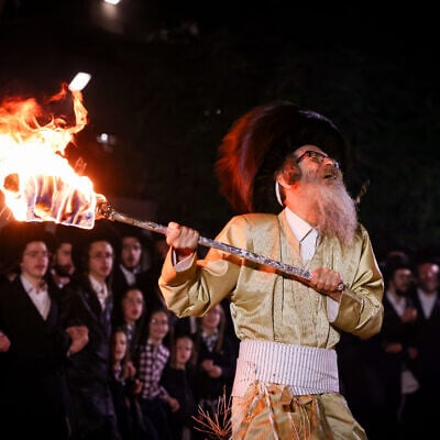 Rabbi Nachman Biderman and his followers light a bonfire during Lag B'Omer celebrations, in Meron, on May 16, 2025. (David Cohen/Flash90)