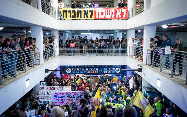 Anti-war protesters take cover at an underground parking lot in Tel Aviv as a siren sounds warning of incoming ballistic missiles fired toward Israel, April 4, 2026. (Flash90)