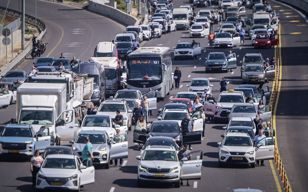 People stand still in the Ayalon Highway in Tel Aviv, as a two-minute siren is sounded across Israel to mark Holocaust Remembrance Day on April 14, 2026 (Avshalom Sassoni/Flash90)