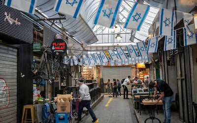 People shop at the Mahane Yehuda Market in Jerusalem on April 15, 2026. (Yonatan Sindel/Flash90)