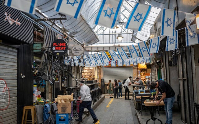 People shop at the Mahane Yehuda Market in Jerusalem on April 15, 2026. (Yonatan Sindel/Flash90)