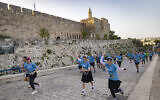 Thousands of runners take part in the annual Jerusalem Marathon near the Old City walls in Jerusalem, April 17, 2026. (Yonatan Sindel/Flash90)