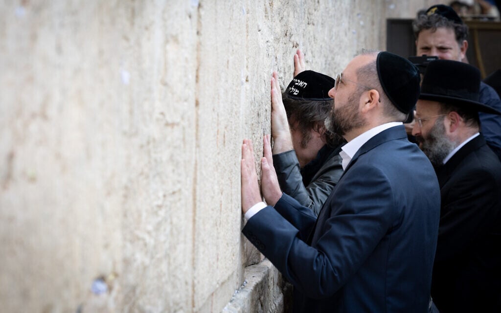Argentinian President Javier Milei (C) touches the Western Wall, in Jerusalem's Old City, April 19, 2026 (Chaim Goldberg/Flash90)