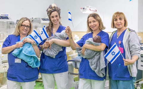 Babies and medical staff with Israeli flags at the Nahariya Medical Center, ahead of Independence Day, April 13, 2026. (Yossi Aloni/FLASH90)