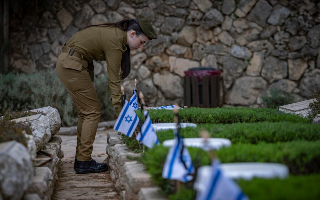 IDF soldiers place Israeli flags on graves of soldiers during the flag laying ceremony in Mount Herzl Military Cemetery in Jerusalem, on April 19, 2026, ahead of Memorial Day. (Yonatan Sindel/Flash90)