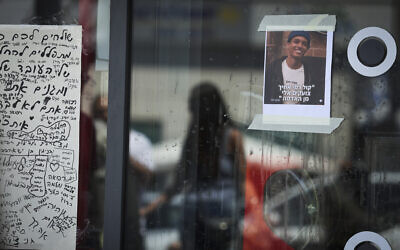 People light candles and post messages outside a Pizza Hut in Petah Tikva, central Israel, on April 24, 2026, in memory of slain worker Yemanu Binyamin Zelka, 21, who was ambushed at the end of his shift on Independence Day night by a group of teens he had asked to stop using party spray in the restaurant. A picture of Zelka is captioned with Gen. 4:10, 'Your brother's blood cries out at me from the ground.' (Roy Alima/Flash90)