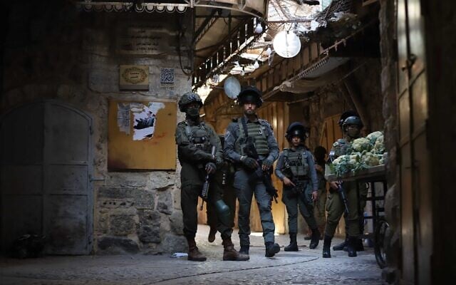 Fuerzas de seguridad israelíes custodian a judíos que realizan una visita guiada en la ciudad de Hebrón, en Cisjordania, el 25 de abril de 2026. (Wisam Hashlamoun/Flash90)