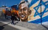 A child walks in front of a memorial mural of Yemanu Zelka, who was stabbed to death in Petah Tikva on Independence Day a week earlier, Ashdod, April 28, 2026. (Liron Moldovan/Flash90)