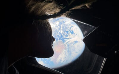 Astronaut and Artemis II mission specialist Christina Koch peers out of one of the Orion spacecraft's main cabin windows on Thursday, April 2, 2026. (NASA/AP)