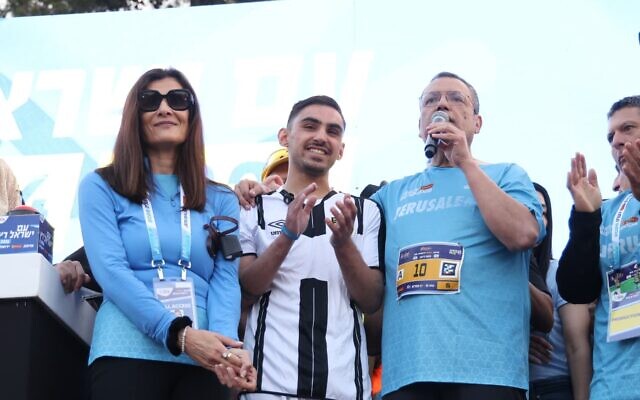 Freed hostage Ram Braslavski (center) and Jerusalem Mayor Moshe Lion (right) at the start of the 10km race on April 17, 2026. (sportphotography via Jerusalem Municipality)