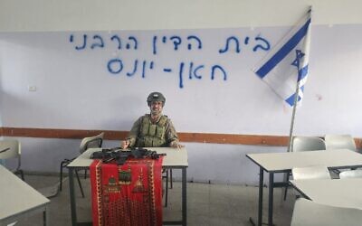 This undated photo shows Rabbi Avraham Zarbiv posing seated at a desk in a building in Gaza with the words 'Rabbinical Court of Khan Younis' written on a whiteboard behind him. (X/Used in accordance with Clause 27a of the Copyright Law)