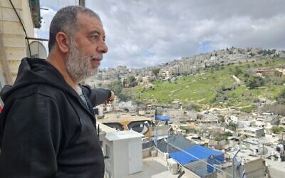 Zuhair Rajabi on the balcony of his home in Silwan, March 31, 2026. (Nurit Yohanan/Times of Israel)