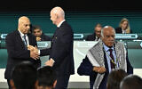 FIFA President Gianni Infantino shakes hands with Basim Sheikh Suliman (left), vice president of the Israeli Football Association, as Jibril Rajoub (right), president of the Palestine Football Association, leaves the stage at the 76th FIFA Congress in Vancouver, Canada on April 30, 2026. (Reuters/Jennifer Gauthier)