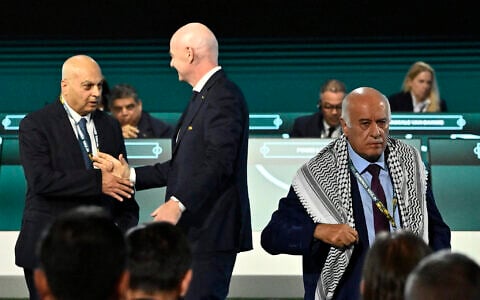 FIFA President Gianni Infantino shakes hands with Basim Sheikh Suliman (left), vice president of the Israeli Football Association, as Jibril Rajoub (right), president of the Palestine Football Association, leaves the stage at the 76th FIFA Congress in Vancouver, Canada on April 30, 2026. (Reuters/Jennifer Gauthier)