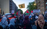 Anti-Zionist protesters with a Hezbollah flag outside a synagogue in New York City, May 11, 2026. (Luke Tress/Times of Israel)